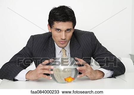 Businessman holding fishbowl with goldfish View Large Photo Image Stock Image - Businessman holding fishbowl with goldfish. Fotosearch
