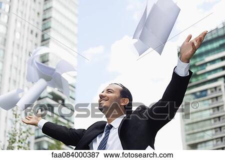 Businessman throwing paper in air, smiling View Large Photo Image Stock Photo - Businessman throwing paper in air, smiling. Fotosearch