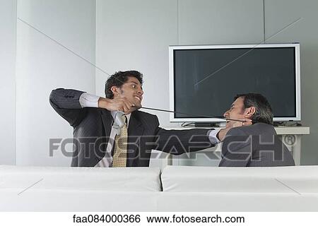 Businessman tied video game controller cable around colleague's neck View Large Photo Image Stock Photograph - Businessman tied video game controller cable around colleague's neck. Fotosearch