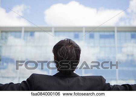 Stock Photograph - Businessman with arms outstretched, rear view. Fotosearch