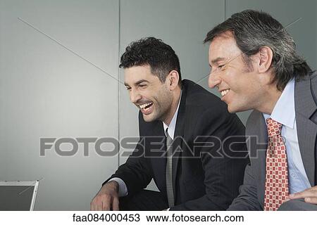 Businessmen in meeting, smiling View Large Photo Image Stock Image - Businessmen in meeting, smiling. Fotosearch