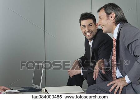 Businessmen in meeting, smiling View Large Photo Image Stock Photography - Businessmen in meeting, smiling. Fotosearch
