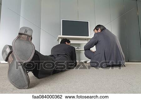Businessmen relaxing on the floor, rear view View Large Photo Image Stock Image - Businessmen relaxing on the floor, rear view. Fotosearch