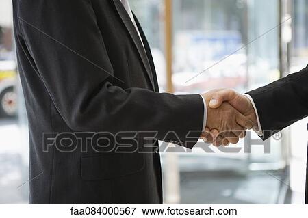 Stock Photo - Businessmen shaking hands, cropped. Fotosearch
