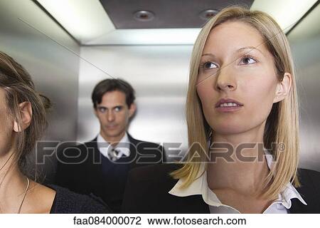 Stock Image - Businesswoman on elevator. Fotosearch