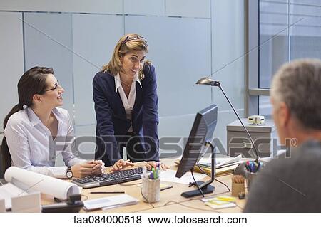 Businesswoman talking with colleagues in office View Large Photo Image Stock Photo - Businesswoman talking with colleagues in office. Fotosearch