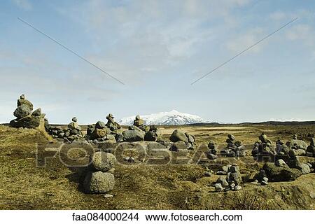 Picture - Cairns volcanic stone on a background of snowy mountains, Iceland Gullfoss. Fotosearch
