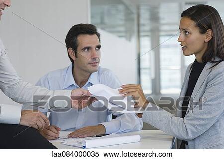 Colleagues discussing documents in meeting View Large Photo Image Stock Photography - Colleagues discussing documents in meeting. Fotosearch