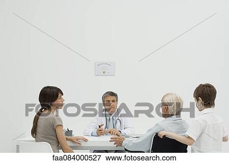 Stock Photo - Doctor talking with senior patient and his family. Fotosearch