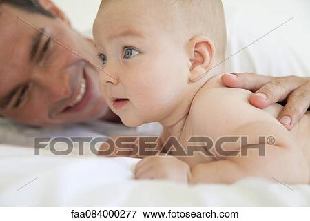 Father lying down with baby boy View Large Photo Image Stock Photo - Father lying down with baby boy. Fotosearch