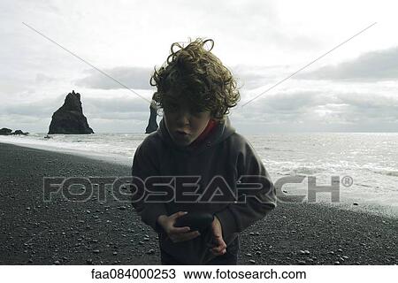 Grimacing boy on a beach iceland View Large Photo Image Stock Image - Grimacing boy on a beach iceland. Fotosearch