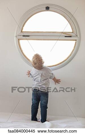 Little boy looking out window, rear view View Large Photo Image Stock Photography - Little boy looking out window, rear view. Fotosearch