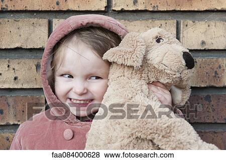 Little girl hugging stuffed dog, portrait View Large Photo Image Stock Photo - Little girl hugging stuffed dog, portrait. Fotosearch
