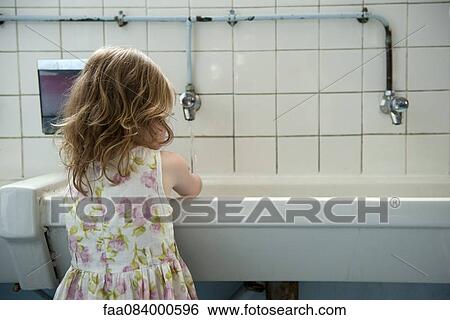 Little girl washing hands in bathroom, rear view View Large Photo Image Stock Photograph - Little girl washing hands in bathroom, rear view. Fotosearch