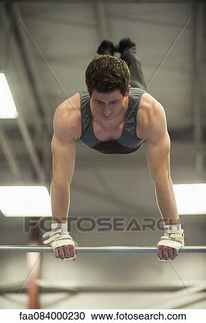 Male gymnast on horizontal bar View Large Photo Image Stock Image - Male gymnast on horizontal bar. Fotosearch