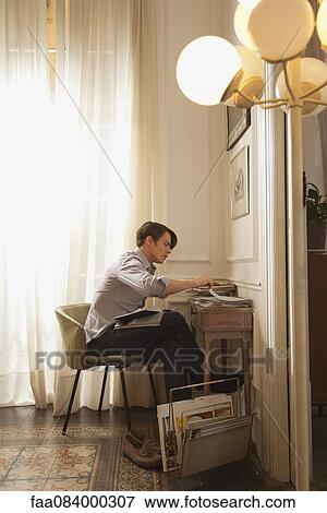 Man reading at desk at home View Large Photo Image Stock Photo - Man reading at desk at home. Fotosearch