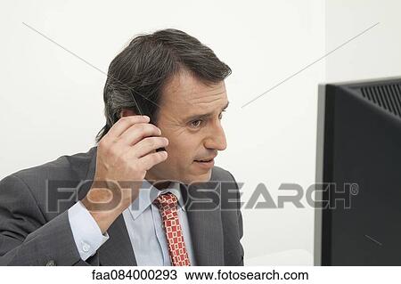 Mature businessman combing hair at desk View Large Photo Image Stock Image - Mature businessman combing hair at desk. Fotosearch