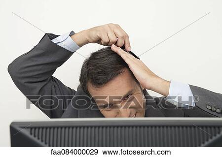 Mature businessman combing hair at desk View Large Photo Image Stock Photo - Mature businessman combing hair at desk. Fotosearch