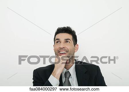 Stock Photo - Mid-adult business daydreaming, smiling. Fotosearch
