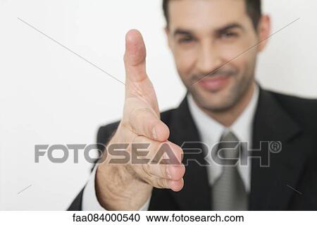 Mid-adult businessman extending hand for handshake View Large Photo Image Stock Image - Mid-adult businessman extending hand for handshake. Fotosearch