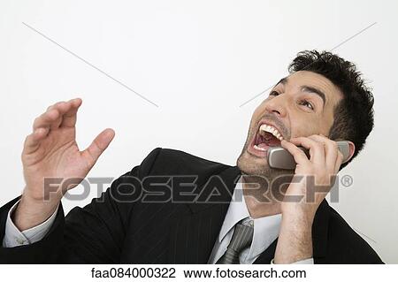 Mid-adult businessman laughing out loud while talking on cell phone View Large Photo Image Stock Image - Mid-adult businessman laughing out loud while talking on cell phone. Fotosearch