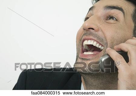 Mid-adult businessman laughing while talking on cell phone, cropped View Large Photo Image Stock Photography - Mid-adult businessman laughing while talking on cell phone, cropped. Fotosearch