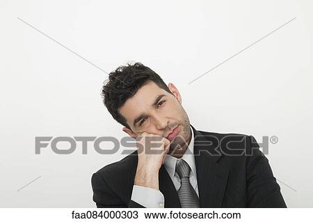Stock Image - Mid-adult businessman looking bored. Fotosearch