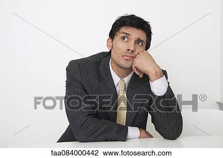 Mid-adult businessman looking bored View Large Photo Image Stock Image - Mid-adult businessman looking bored. Fotosearch