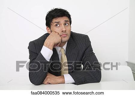 Mid-adult businessman looking bored View Large Photo Image Stock Photography - Mid-adult businessman looking bored. Fotosearch