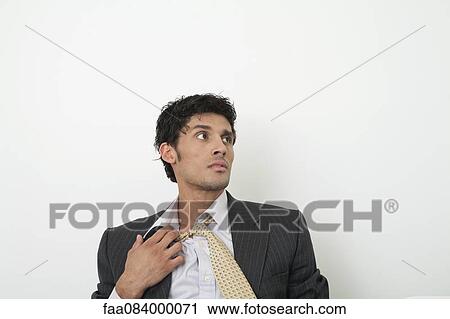 Mid-adult businessman pulling off tie View Large Photo Image Stock Image - Mid-adult businessman pulling off tie. Fotosearch