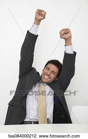 Mid-adult businessman raising arms in celebration View Large Photo Image Stock Image - Mid-adult businessman raising arms in celebration. Fotosearch