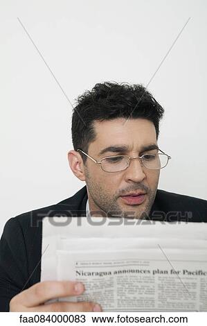 Stock Image - Mid-adult businessman reading newspaper. Fotosearch