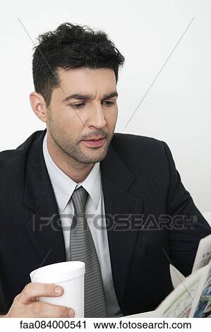 Mid-adult businessman reading newspaper View Large Photo Image Stock Image - Mid-adult businessman reading newspaper. Fotosearch