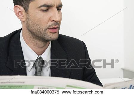 Mid-adult businessman reading newspaper View Large Photo Image Stock Photography - Mid-adult businessman reading newspaper. Fotosearch
