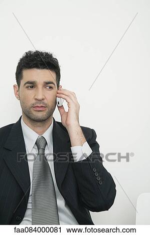 Mid-adult businessman talking on cell phone View Large Photo Image Stock Image - Mid-adult businessman talking on cell phone. Fotosearch