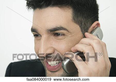Mid-adult businessman talking on cell phone, smiling View Large Photo Image Stock Photo - Mid-adult businessman talking on cell phone, smiling. Fotosearch