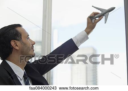 Mid-adult executive playing with toy airplane View Large Photo Image Stock Image - Mid-adult executive playing with toy airplane. Fotosearch