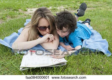 Mother and young son lying on blanket, working puzzles in newspaper together View Large Photo Image Stock Image - Mother and young son lying on blanket, working puzzles in newspaper together. Fotosearch