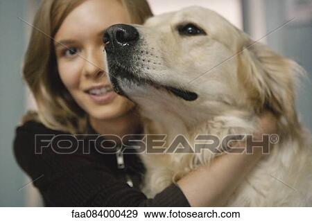 Teenage girl hugging golden retriever View Large Photo Image Stock Photo - Teenage girl hugging golden retriever. Fotosearch