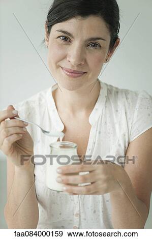 Woman eating yogurt, portrait View Large Photo Image Stock Photo - Woman eating yogurt, portrait. Fotosearch