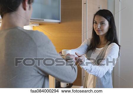 Woman handing man cup of coffee View Large Photo Image Picture - Woman handing man cup of coffee. Fotosearch