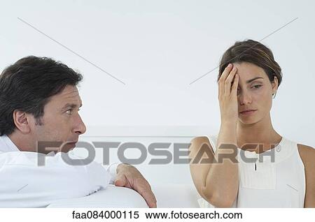 Woman holding head as man watches View Large Photo Image Stock Photography - Woman holding head as man watches. Fotosearch