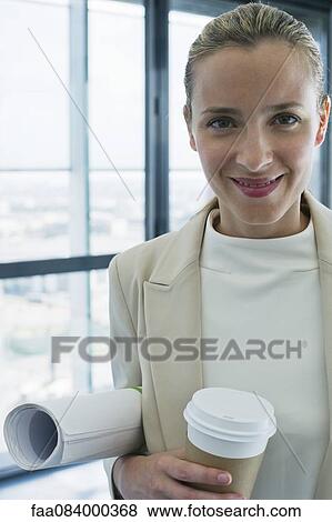 Woman holding rolled up blueprints and disposable coffee cup, portrait View Large Photo Image Stock Photo - Woman holding rolled up blueprints and disposable coffee cup, portrait. Fotosearch