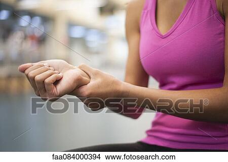 Woman holding wrist, cropped View Large Photo Image Picture - Woman holding wrist, cropped. Fotosearch