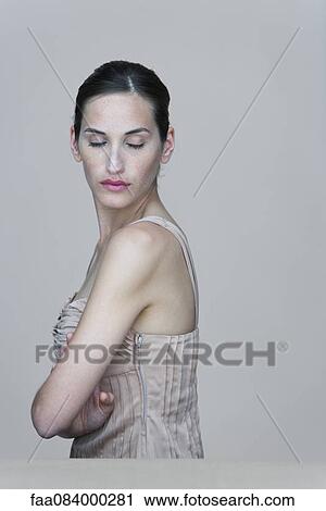 Stock Image - Woman with arms folded and eyes closed. Fotosearch