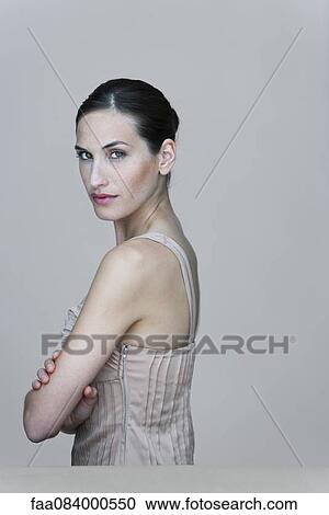 Woman with arms folded, looking over shoulder, portrait View Large Photo Image Stock Image - Woman with arms folded, looking over shoulder, portrait. Fotosearch