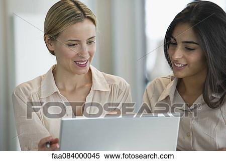 Women working together with laptop computer View Large Photo Image Stock Photography - Women working together with laptop computer. Fotosearch