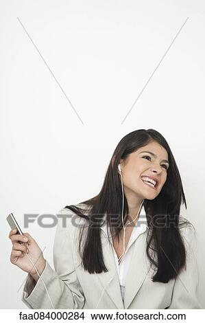 Young businesswoman listing to music on mp3 player View Large Photo Image Picture - Young businesswoman listing to music on mp3 player. Fotosearch