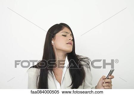 Young businesswoman listing to music on mp3 player View Large Photo Image Stock Photography - Young businesswoman listing to music on mp3 player. Fotosearch