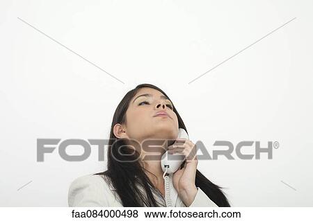 Young businesswoman talking on landline phone View Large Photo Image Stock Photo - Young businesswoman talking on landline phone. Fotosearch